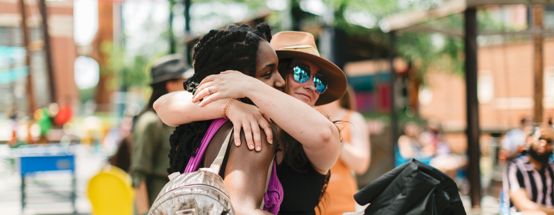 two people hugging outside at a market