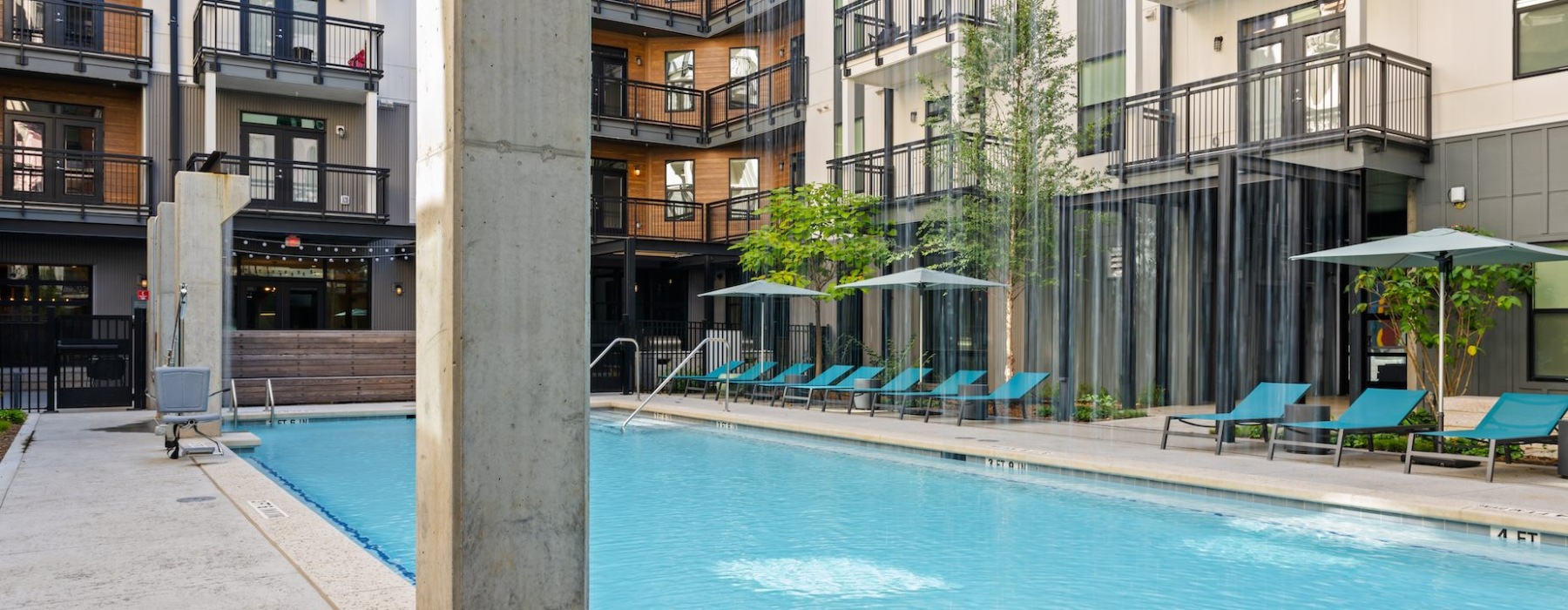 Pool-level view of the lounge area surrounded by Kinship NoDa luxury apartments.