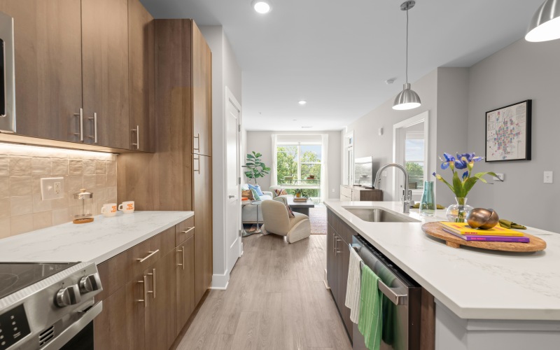 View of the the kitchen with white countertops and stainless steel appliances at Kinship furnished apartments in Charlotte.